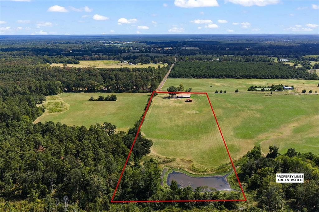 1131 Speights Road Keatchie, LA 71046 - Photo 5 of 33 Expansive rural property featuring a primary residence, a large barn, a substantial pond, open fields, and mature tree lines