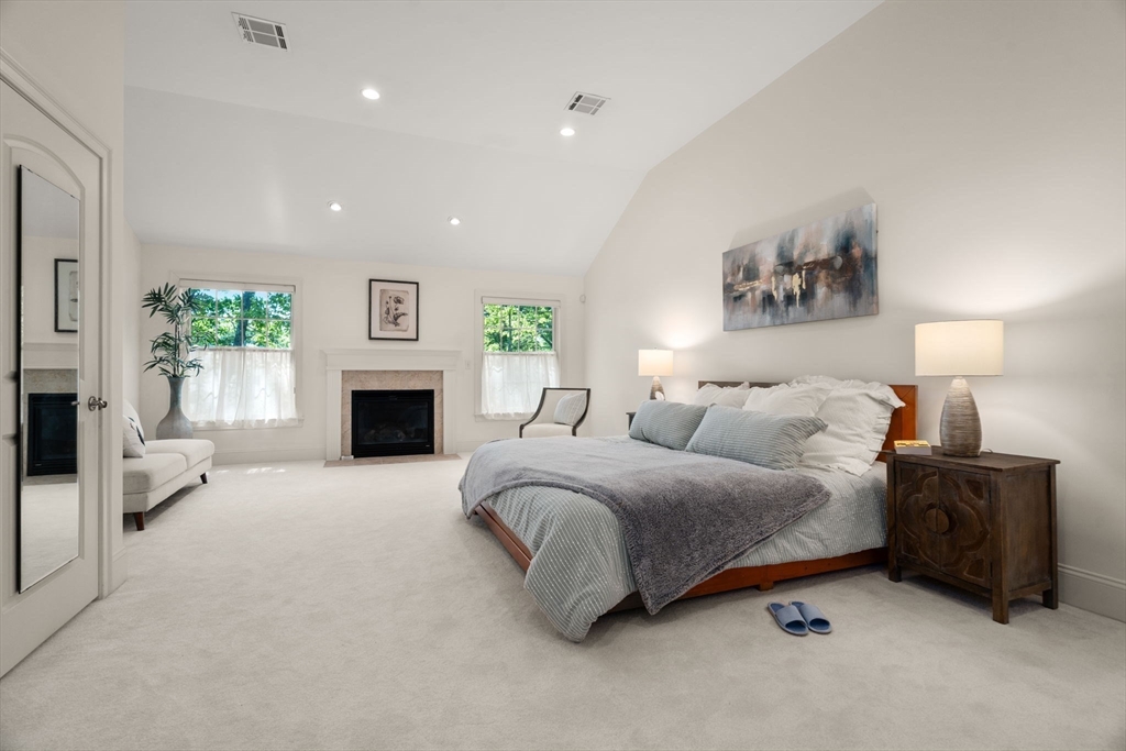 287 Langley Road, Unit 43 Newton, MA 02459 - Photo 23 of 36 a spacious bedroom with a bed and a fireplace