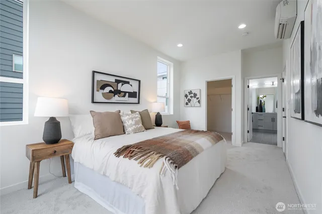 a spacious bedroom with a bed a couch and a view of bathroom