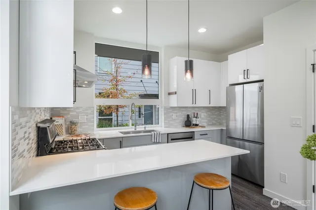 a kitchen with kitchen island a large counter top space a sink stainless steel appliances and cabinets