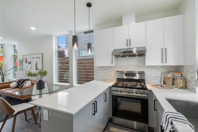 a kitchen with granite countertop a stove a sink and a refrigerator
