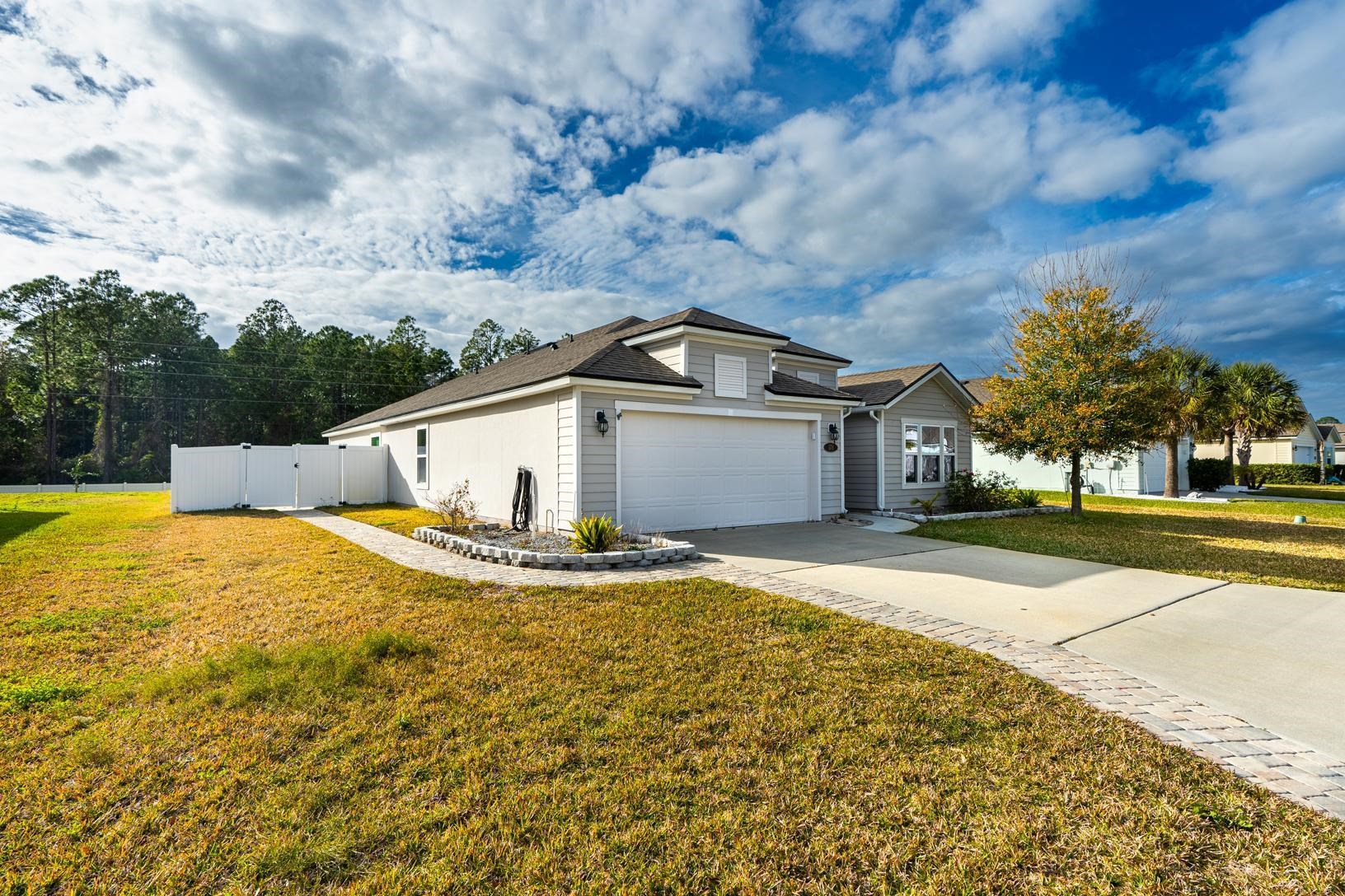 178 South Hamilton Springs Road St. Augustine, FL 32084 - Photo 3 of 26 a view of a white house with a yard and large tree