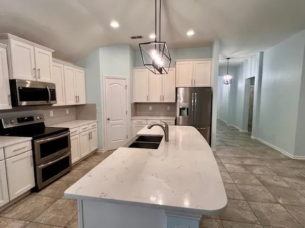 a kitchen with kitchen island a sink stainless steel appliances and counter space