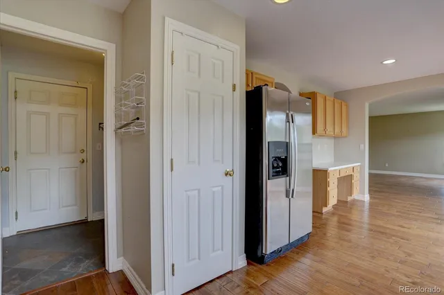 a view of a hallway with wooden floor and cabinets