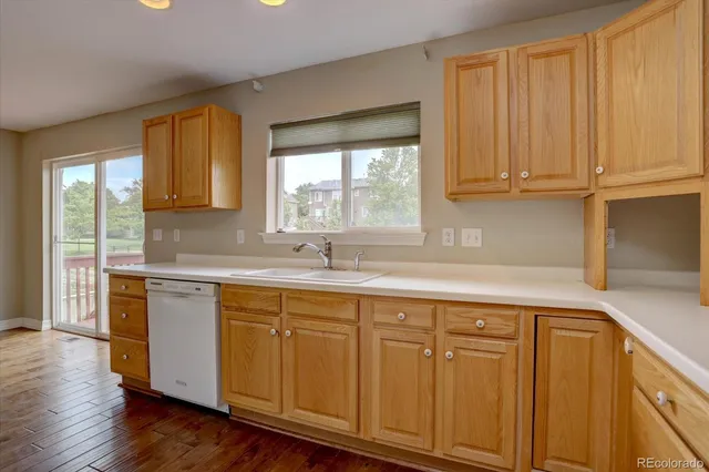 a kitchen with stainless steel appliances granite countertop a sink and cabinets with wooden floor