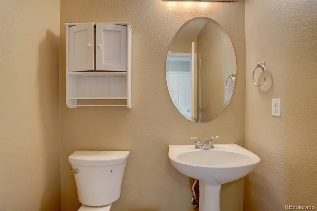 a bathroom with a sink mirror and toilet