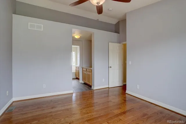a view of an empty room with window and wooden floor