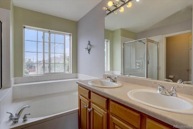 a bathroom with a granite countertop sink mirror and a bathtub