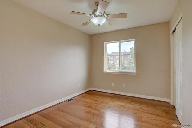 an empty room with a window and a fan