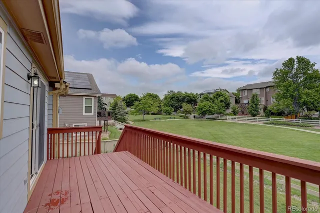 a view of a deck with wooden floor and fence with city view