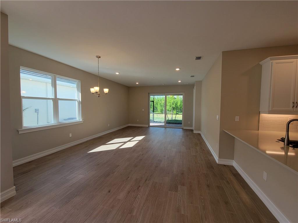 995 Enbrook Loop Naples, FL 34114 - Photo 7 of 42 a view of empty room with wooden floor and fan