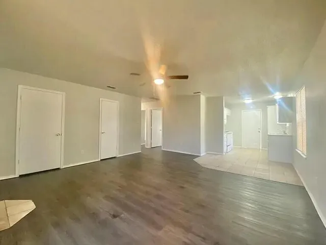 a view of an empty room with wooden floor