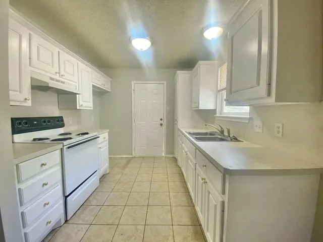 a kitchen with a sink stove and cabinets