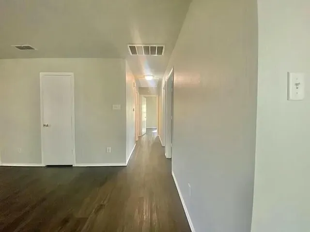 a view of a room with wooden floor