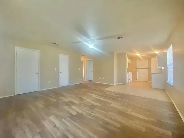 a view of an empty room with a kitchen