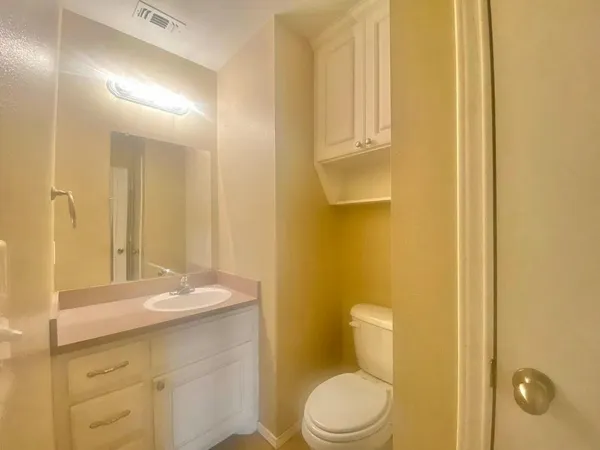 a bathroom with a granite countertop sink a toilet and a mirror