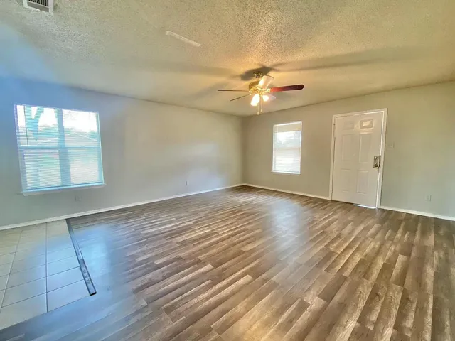 wooden floor in an empty room with a window