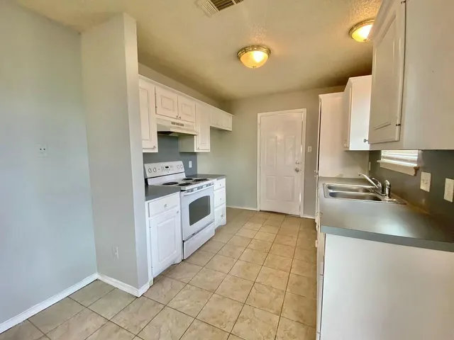 a kitchen with a sink a stove and cabinets