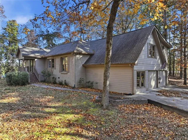 a front view of a house with a tree