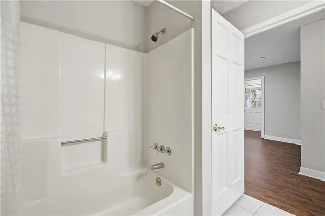 an empty room with windows and fireplace