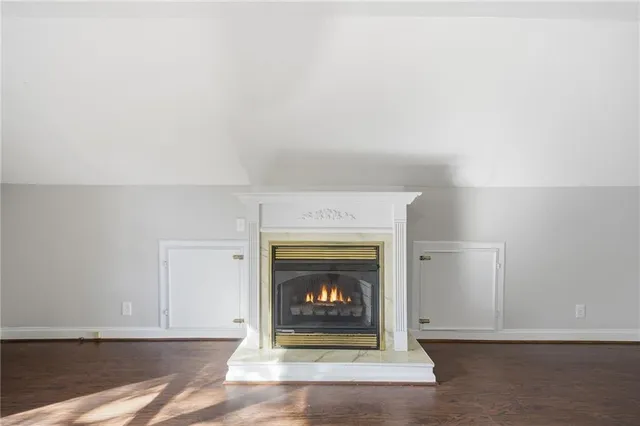 a view of an empty room with a chandelier fan and wooden floor
