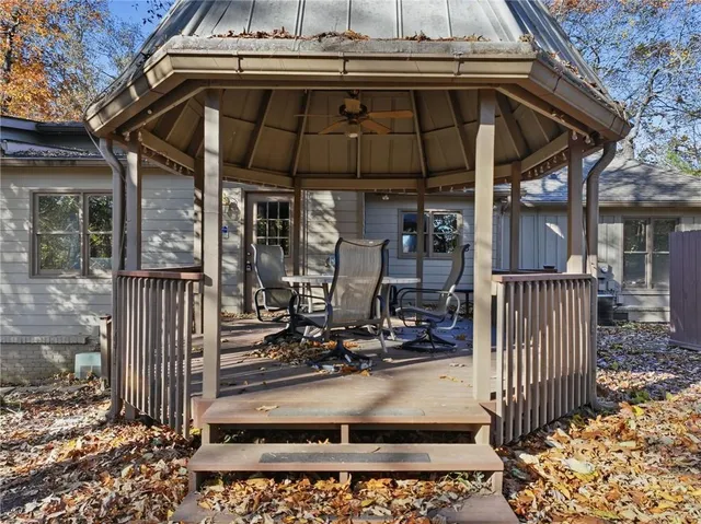 a view of a patio with table and chairs under an umbrella with wooden floor