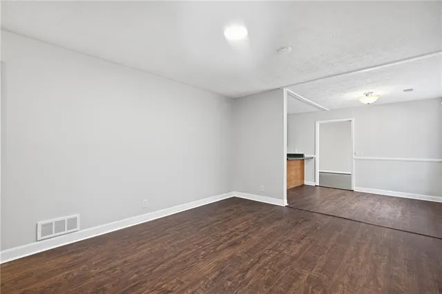 a view of an empty room with wooden floor