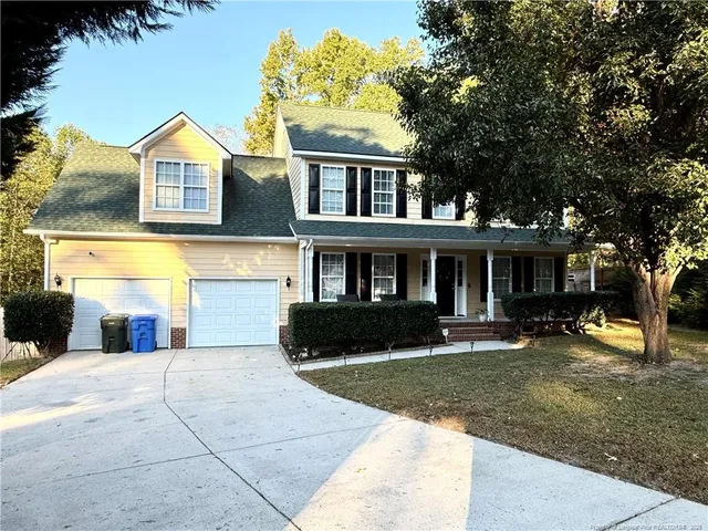 a front view of a house with a yard and trees