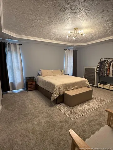 a spacious bedroom with a bed and a chandelier