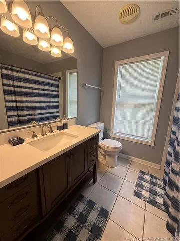 a bedroom with a bed and dresser next to a window