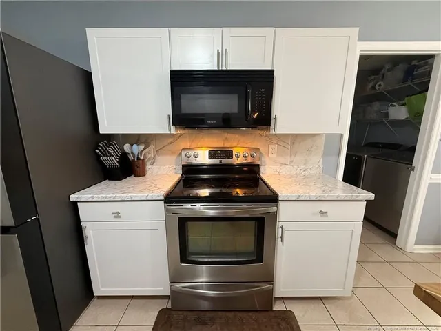 a stove top oven sitting inside of a kitchen