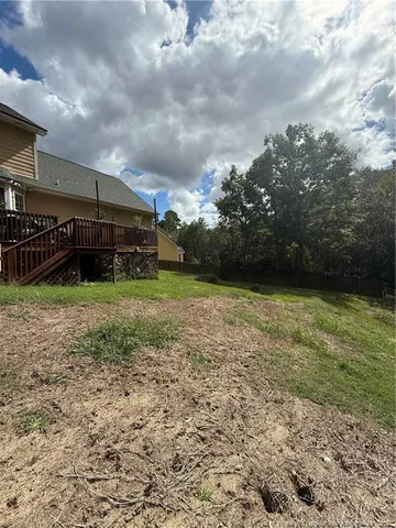 a backyard of a house with barbeque oven and trees