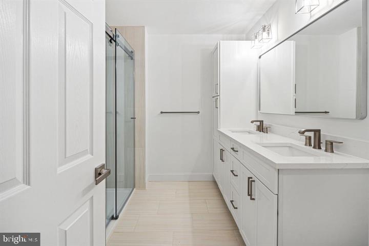 306 South 10th Street, Unit A Philadelphia, PA 19107 - Photo 23 of 36 a bathroom with a double vanity sink and mirror