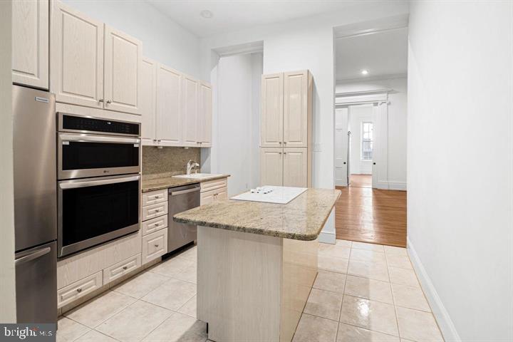 306 South 10th Street, Unit A Philadelphia, PA 19107 - Photo 5 of 36 a kitchen with stainless steel appliances granite countertop a stove a refrigerator and a cabinets