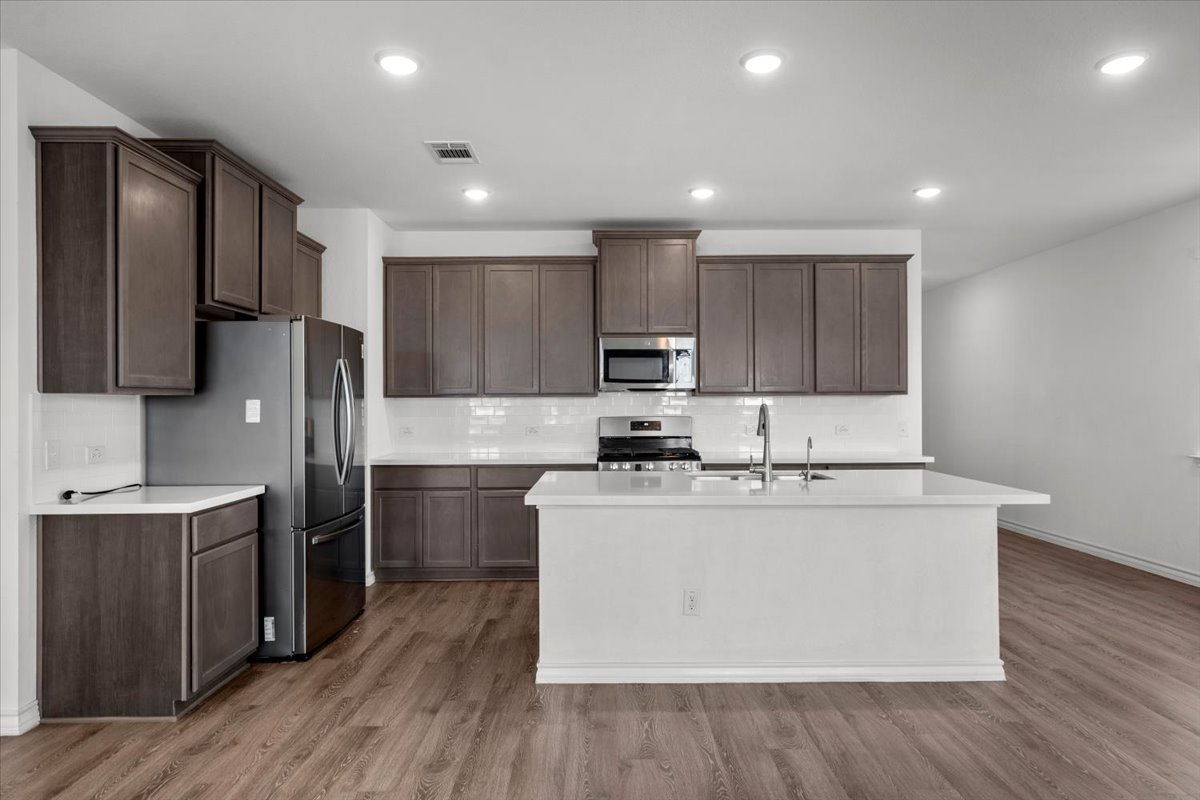 500 Stinchcomb Road Hutto, TX 78634 - Photo 14 of 37 A well-appointed kitchen showcasing contemporary cabinetry, a central island, and modern appliances.
