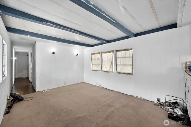 a view of empty room with wooden floor and window