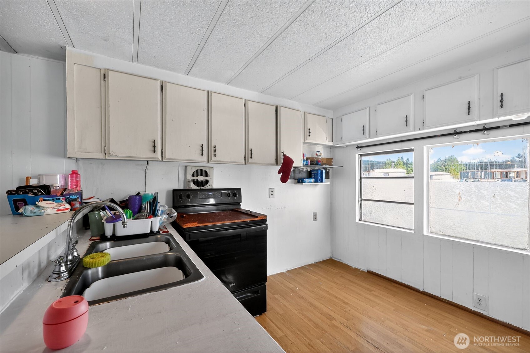 66 Fairgrounds Road, Unit 21 Elma, WA 98541 - Photo 22 of 31 a kitchen with blue cabinets and a wooden floor