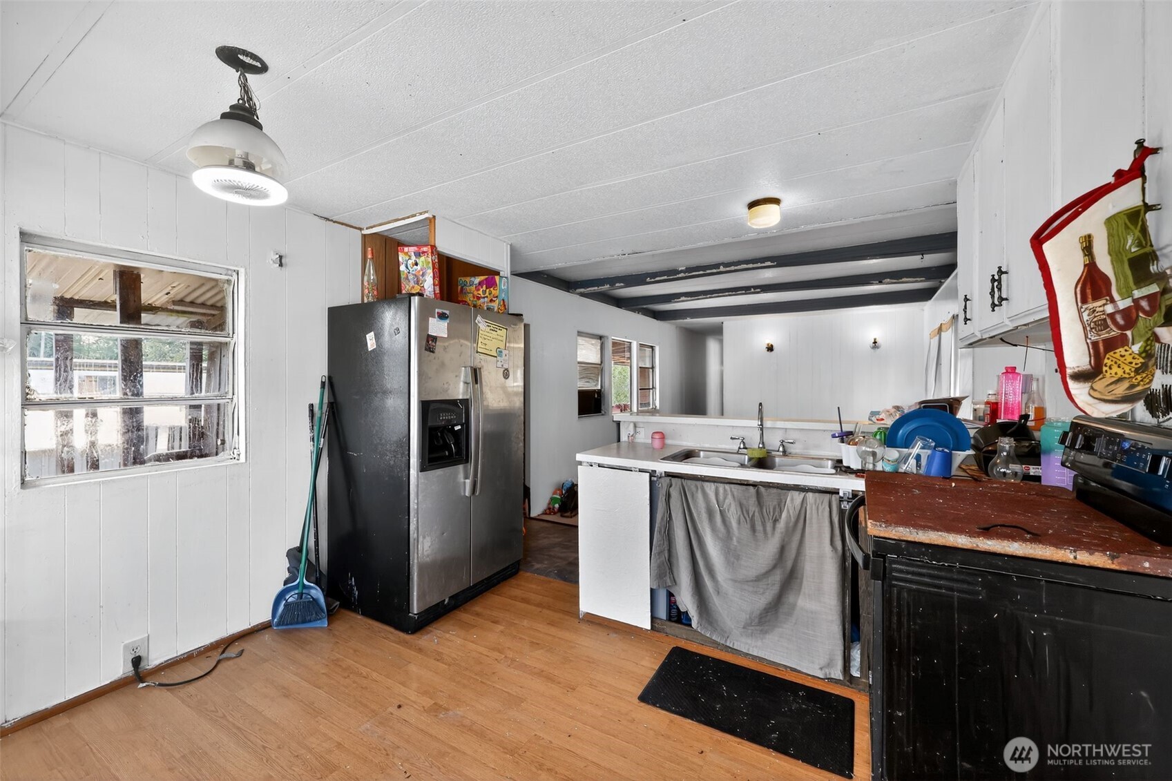 66 Fairgrounds Road, Unit 21 Elma, WA 98541 - Photo 23 of 31 a kitchen with stainless steel appliances granite countertop a refrigerator a sink dishwasher a stove and a dining table with wooden floor