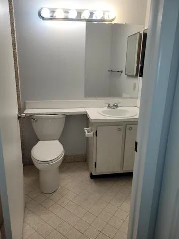 a bathroom with a toilet sink and mirror
