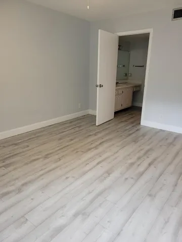 a view of room with wooden floor and bathroom
