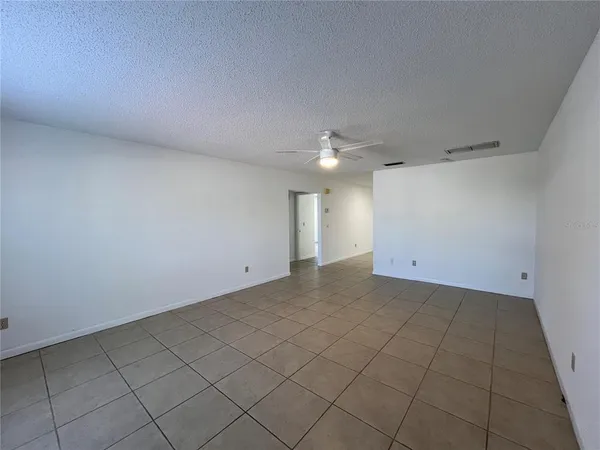 an empty room with a chandelier fan