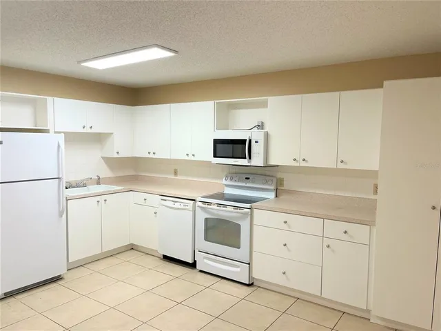 a kitchen with white cabinets stainless steel appliances and sink