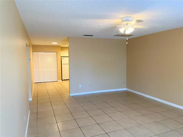 a view of an empty room with a chandelier fan