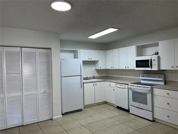 a kitchen with white cabinets stainless steel appliances and sink