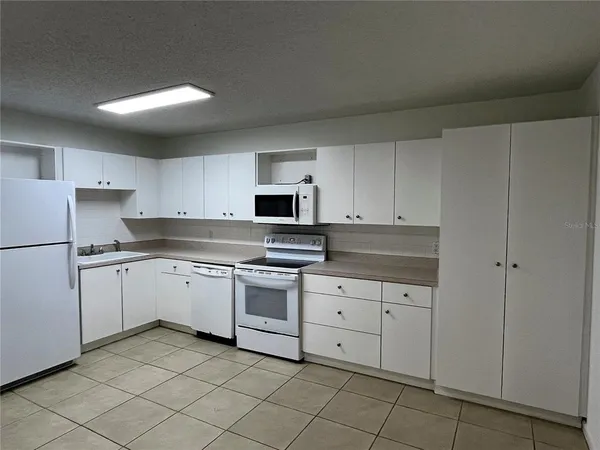 a kitchen with granite countertop cabinets and white appliances
