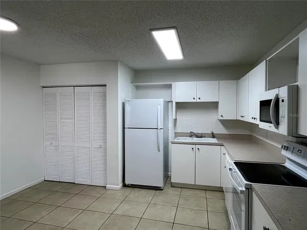a kitchen with stainless steel appliances a refrigerator sink and microwave