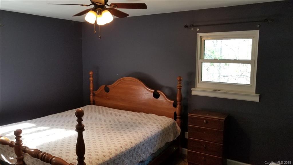 7045 Ridge Lane Road Charlotte, NC 28262 - Photo 17 of 19 a bedroom with a bed and a chandelier