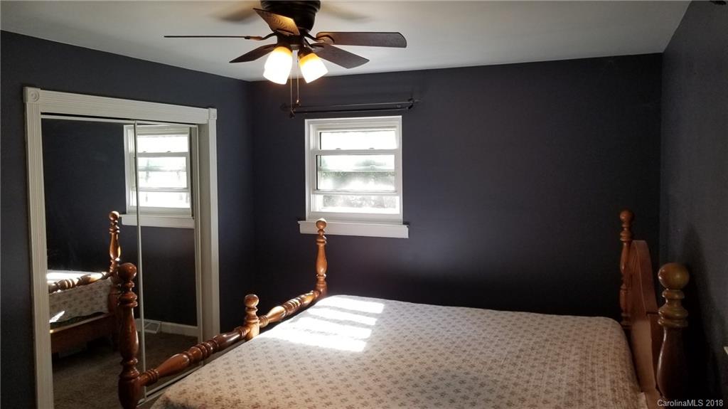 7045 Ridge Lane Road Charlotte, NC 28262 - Photo 18 of 19 a bedroom with a bed and a chandelier