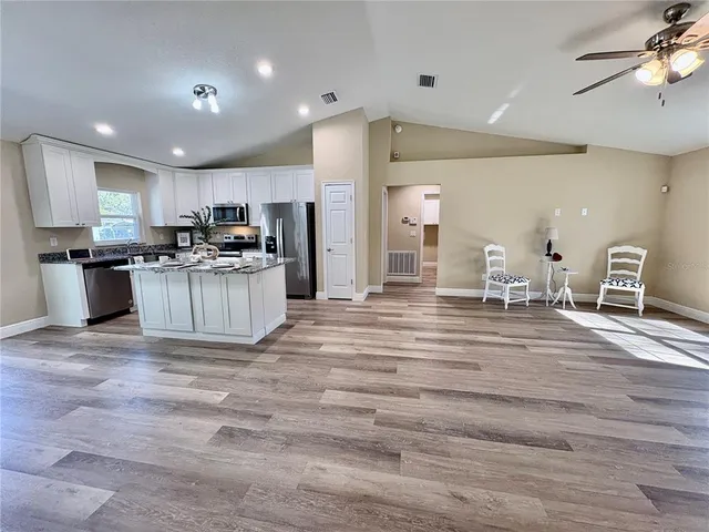 a bathroom with a granite countertop sink a toilet a mirror and shower