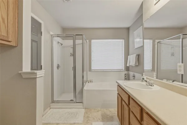 a bathroom with a tub sink and mirror